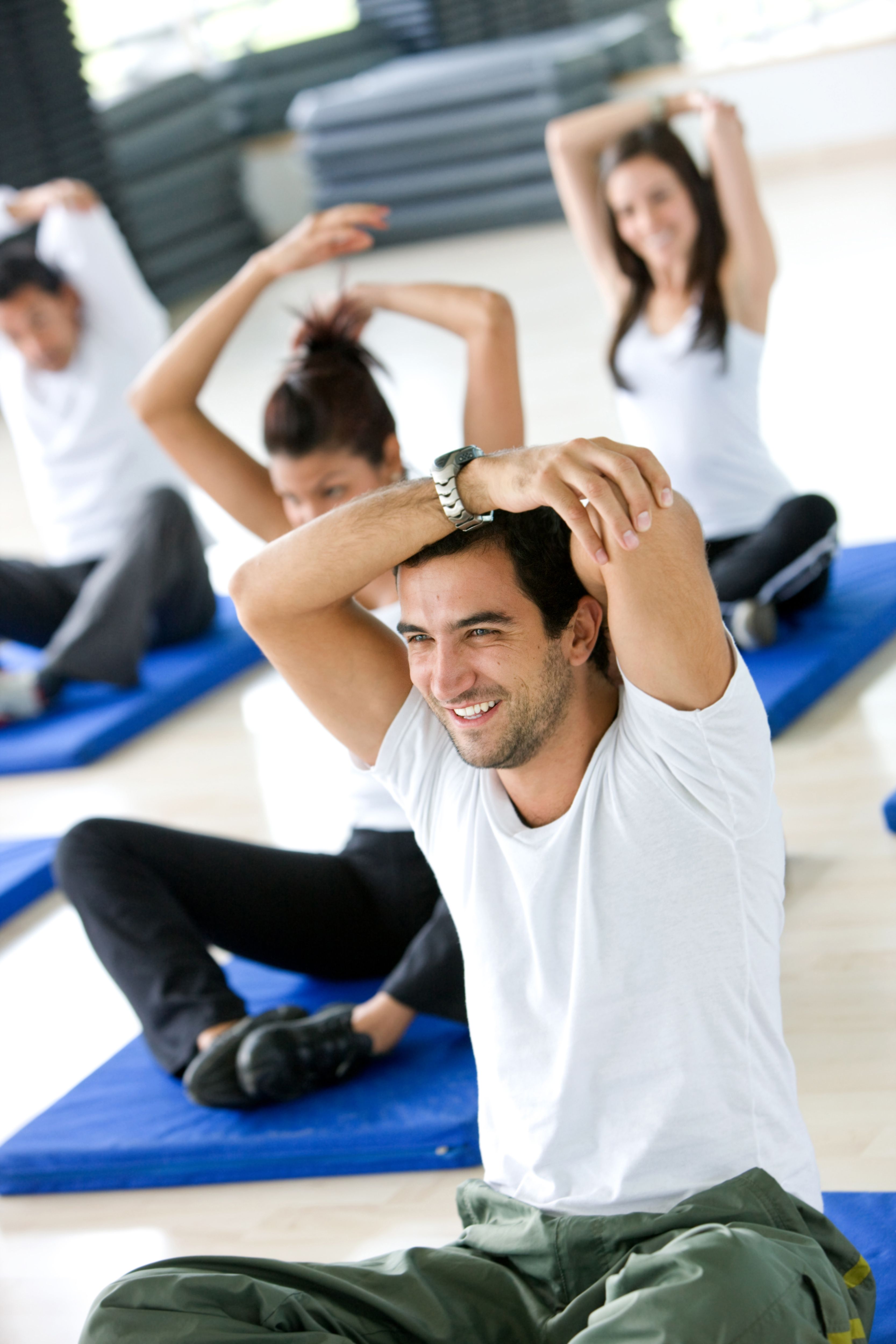 Group of gym people stretching at a gym